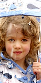 Photo of a young girl holding an umbrella in the rain